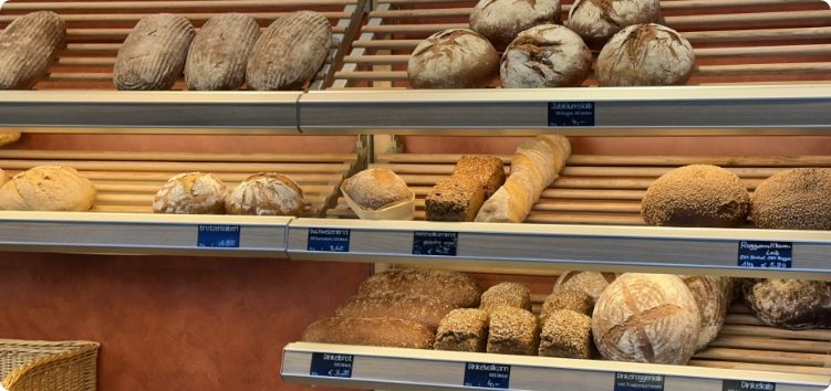Auswahl frischer Brote und Backwaren im Verkaufsregal der Bäckerei Neuner